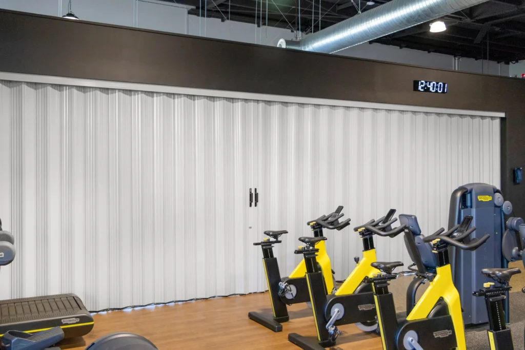 DuraFlex accordion partition dividing a gym space to create flexible workout areas