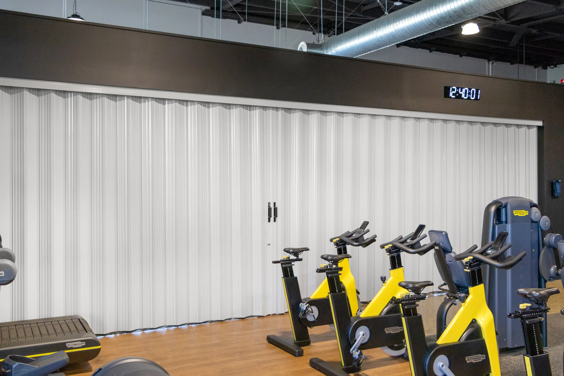 DuraFlex accordion partition dividing a gym space to create flexible workout areas