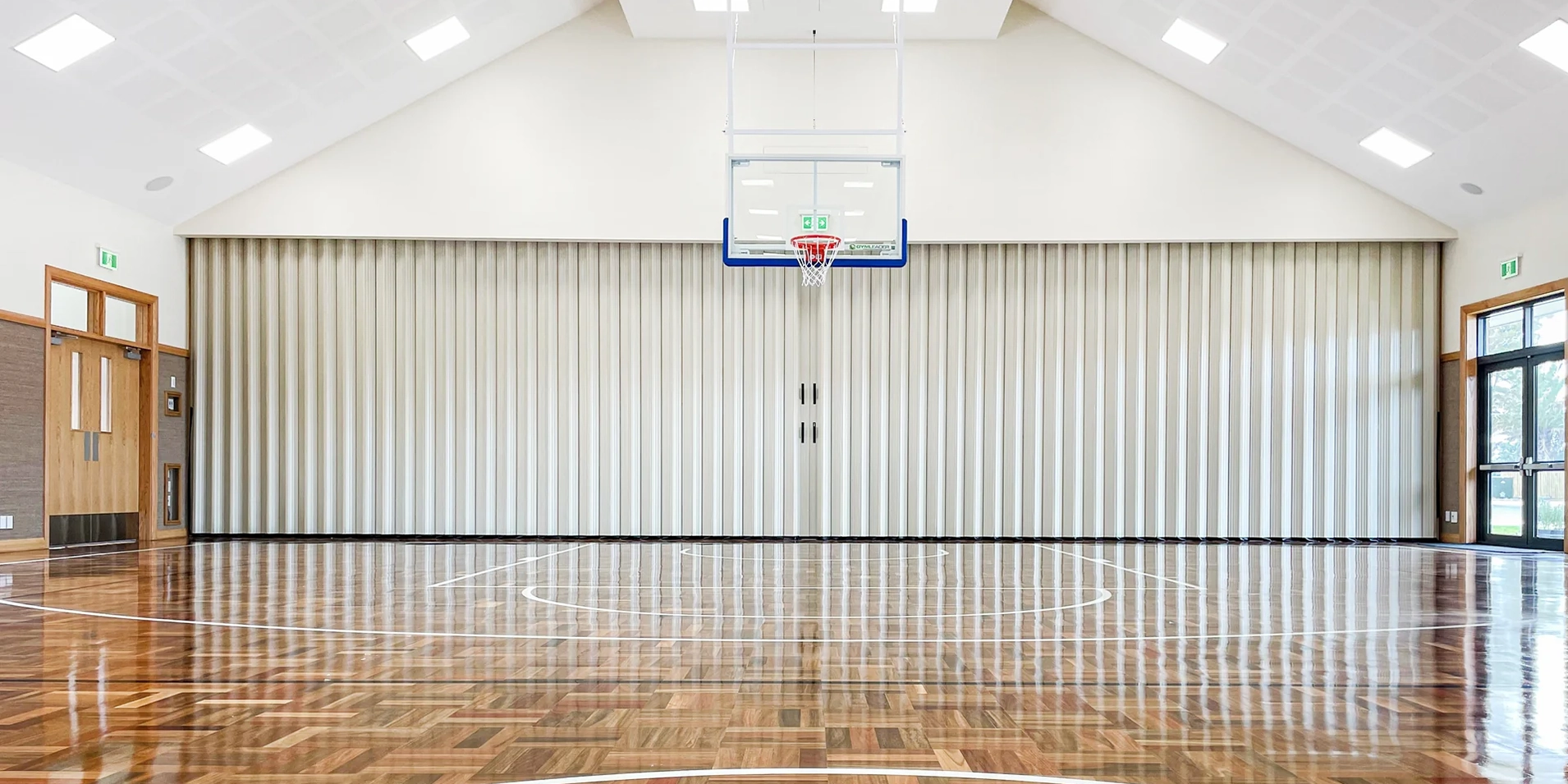 DuraSound acoustic accordion partition spanning a sports hall to divide large multi-use spaces
