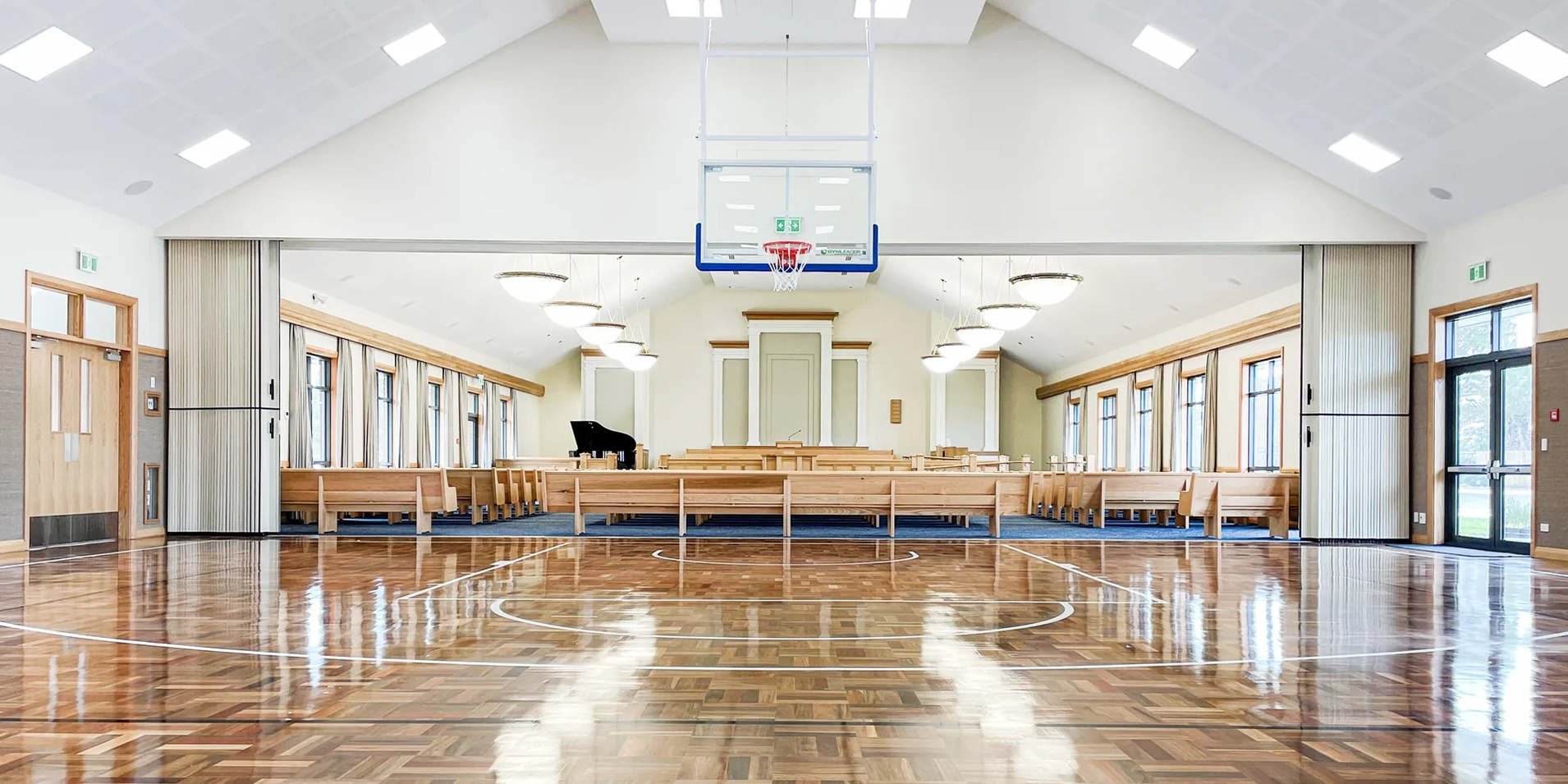 DuraSound acoustic accordion partition stacked to both sides spanning a sports hall to divide large multi-use spaces
