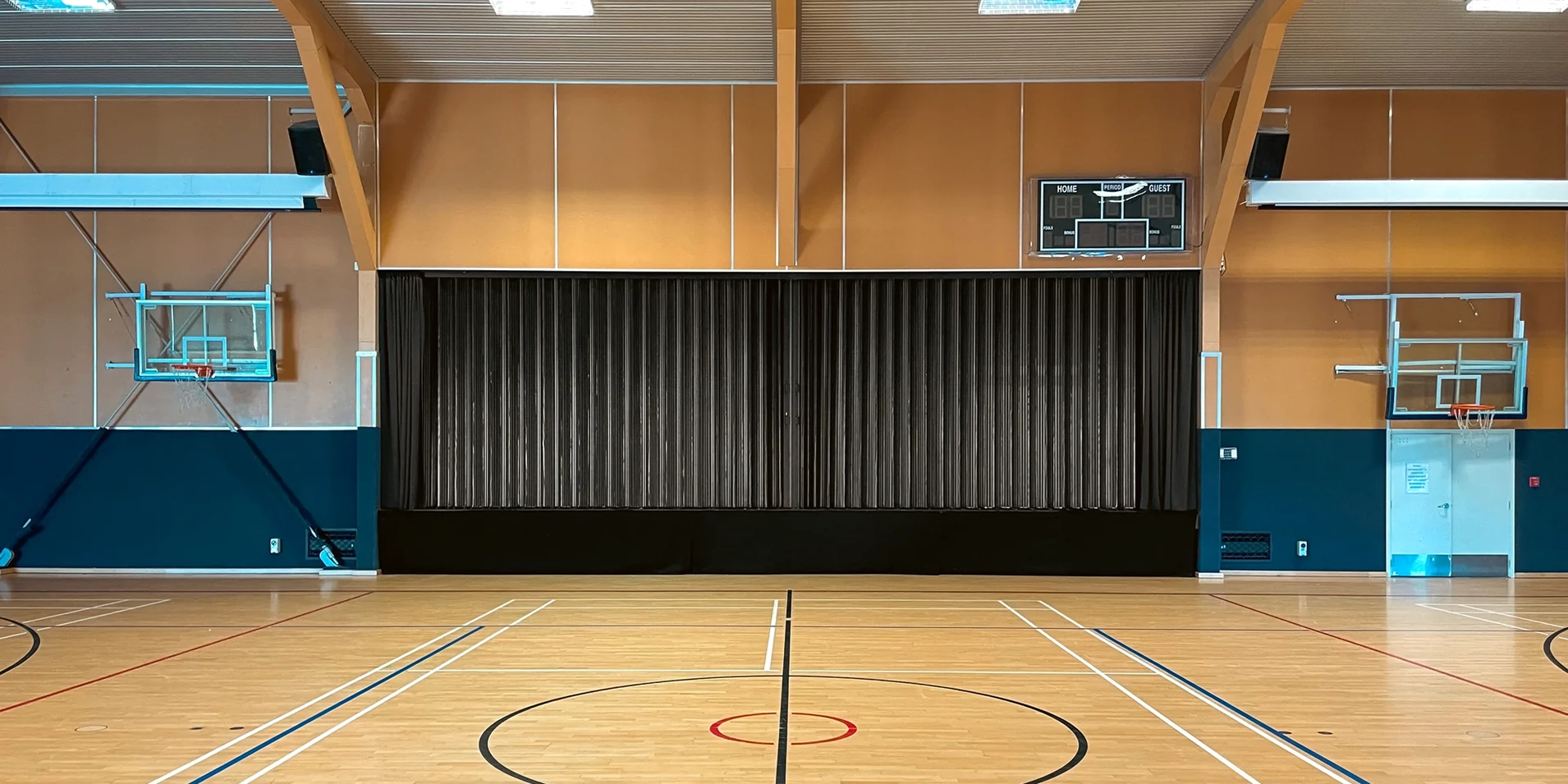 DuraFlex accordion partition dividing a sports hall stage area for flexible use